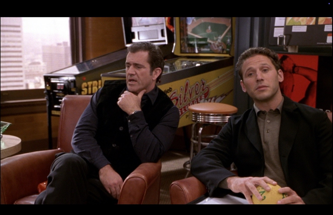Back in his seat, Nick shows worry while Morgan shows thoughtful reaction to what someone else is saying. The Silver Slugger fills the space between the co-workers. The graphics reading “Silver Slugger” and much of the word “Gottlieb” are legible on the side of the machine’s main cabinet body.